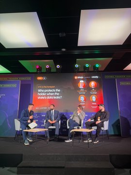 A panel of four people sits on stage at a UKC presentation, discussing the topic displayed on the screen: 'Who protects the forest in the equal strategy?', with the Greater Bay Area, Awards 2026, and Infinitely branding visible.