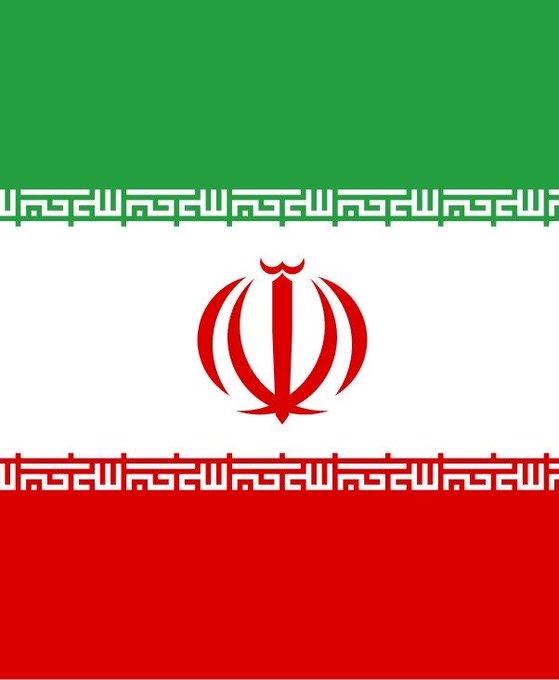 The image shows the flag of Iran, featuring three horizontal stripes of green, white, and red, with the red national emblem (a stylized tulip/Lion of Allah design) centered on the white stripe and Kufic script borders. The flag visually represents the country mentioned in the post, which discusses Iran's reported use of Bitcoin and USDT cryptocurrency to circumvent U.S. sanctions.