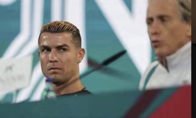 Cristiano Ronaldo sits on the bench with a stern, unimpressed expression, while a teammate or coach in a white tracksuit looks on in the background. The image humorously accompanies the post about $ANSEM, using Ronaldo's iconic serious demeanor to express surprise or disapproval at the omission.