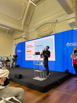 A speaker presents on stage at a 'Câmara de Lisboa' (Lisbon Chamber) event, with a presentation slide visible behind him showing 'Master Pitches'.