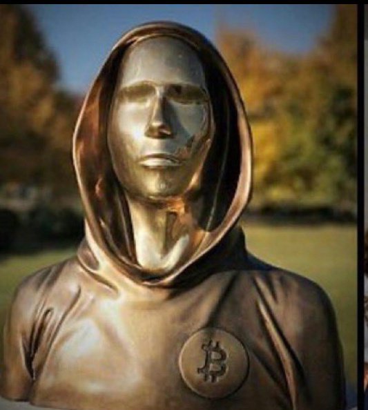 A bronze statue of a hooded figure with a Bitcoin '₿' emblem on its chest.