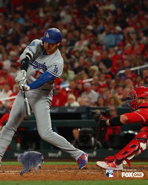 A Los Angeles Dodgers batter, wearing jersey number 7 and a blue helmet, swings at a pitch with the catcher in red gear crouched behind home plate. The FOX ONE broadcast logo is visible in the bottom right corner, and a cat graphic overlays the bottom of the image, tying into the playful "$Jimothy is no brainer" caption that humorously pairs the swinging motion with the cat's agile leap.