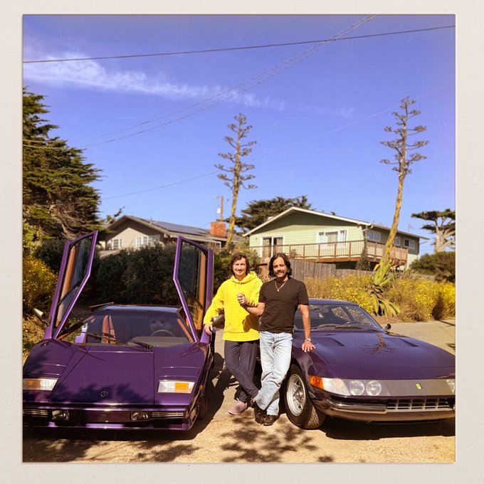 Two men pose between two matching purple Lamborghini Countaches—one a vintage model with scissor doors open, the other a modern Diablo—with the caption "me and my homies" playfully suggesting the rare twin supercars are their friends.