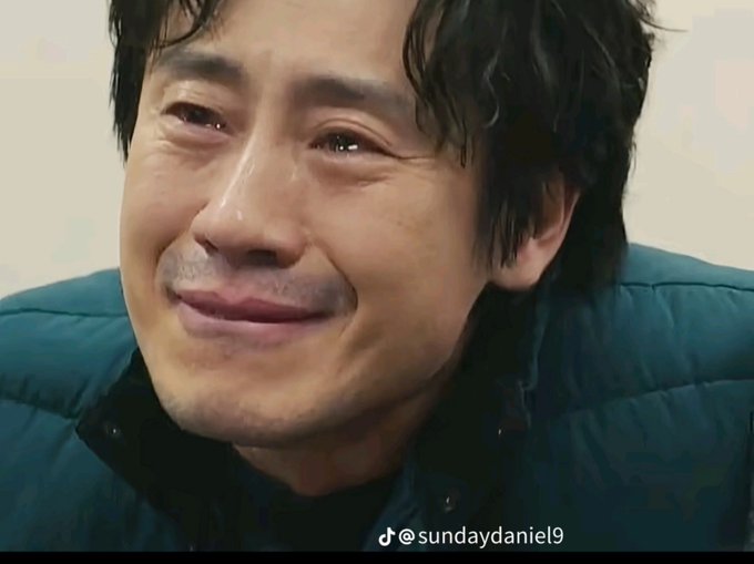 A close-up of a man with wet dark hair crying emotionally, wearing a teal puffer jacket, with a TikTok watermark '@sundaydaniel9' visible.