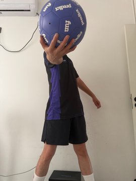 A man in purple and black athletic wear is holding up a blue "predict" soccer ball in front of his face, showcasing the free World Cup merchandise he received from Predict.fun, as mentioned in his post about trading prediction market losses for promotional items and points.