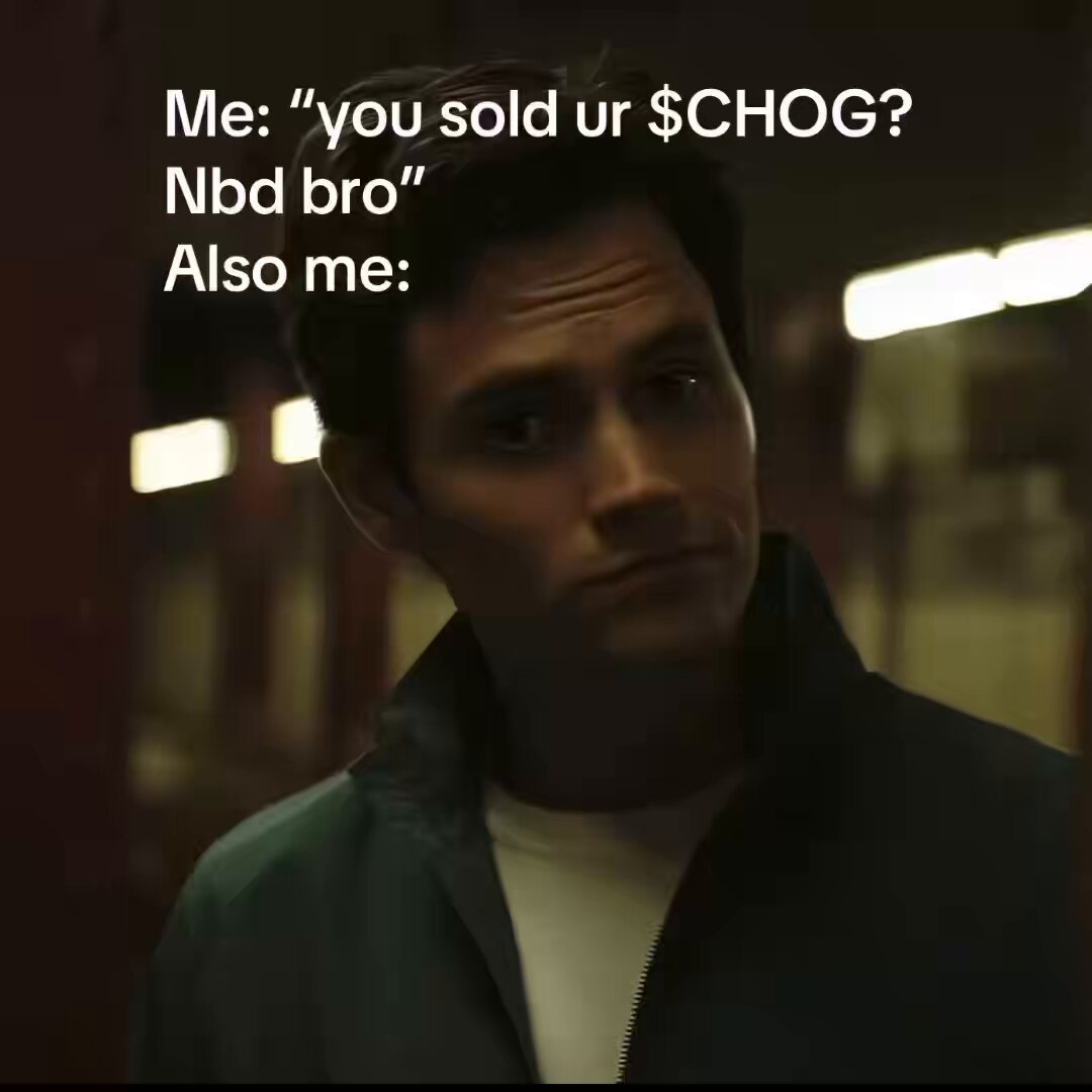 The image shows a man wearing a jacket, with his face partially visible behind him. The background appears blurry, but there are some lights that could be coming from an exit or entrance of a building. The caption at the bottom of the image reads "You sold ur $CHOG?".