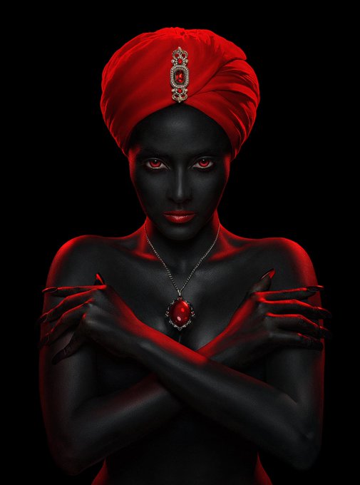 A striking digital portrait of a woman with dark skin wearing a red turban adorned with a jeweled brooch, a red gemstone necklace, and long red fingernails, set against a black background.
