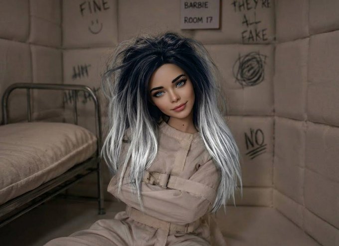 A person in a straitjacket with long black and silver hair sits in a padded cell, with walls covered in graffiti reading "FINE", "BARBIE ROOM 17", "THEY'RE ALL FAKE", and "NO".
