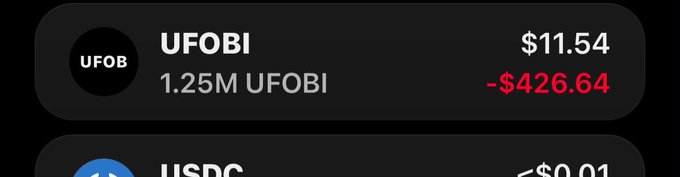 A mobile wallet screen showing holdings of UFOBI (1.25M UFOBI, $11.54, -$426.64) and USDC.