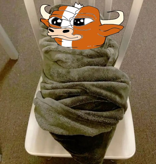 A gray blanket rolled up on a white plastic chair with an angry Tampa Bay Buccaneers mascot sticker overlaid on top.