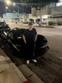 A young man poses confidently next to a black car on a city street at night, visually representing the lifestyle and financial success that the post suggests could be achieved by building memecoins on Pump.fun rather than trading them.