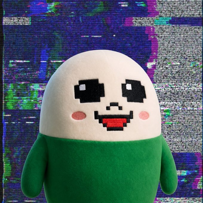 A plush toy character with a pixelated smiley face on a white egg-shaped body and green lower half, set against a glitchy, distorted background.