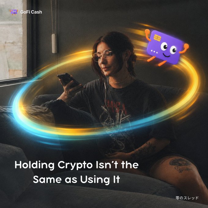 Promotional image for GoFi Cash featuring a woman wearing headphones looking at her phone with a colorful swirling light effect and an animated purple card character, captioned 'Holding Crypto Isn't the Same as Using It.'