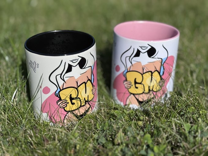 Two ceramic mugs sitting on grass, decorated with a graffiti-style illustration of a faceless figure holding a yellow tag that reads "BMW".