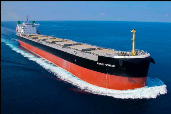 Aerial photograph of the 'BRAVE PIONEER' bulk carrier ship sailing through blue ocean waters.