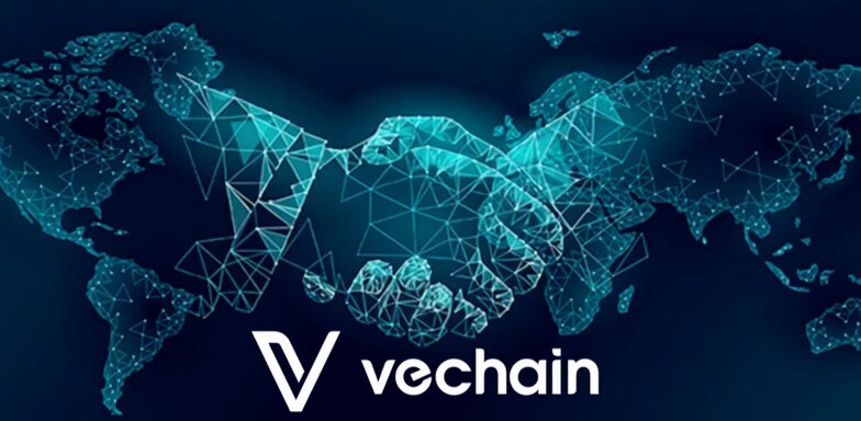 The image features a logo for VeChain, which is an online marketplace that connects sellers with buyers. The logo includes a map of the world surrounded by blue triangles representing connections between people. The text "Vechain" is written below the map, indicating the name of the platform. The main focus of the image is on the handshake symbol, which represents trust and collaboration in business relationships.
