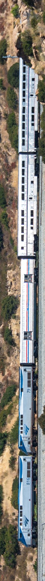 The image (rotated sideways) shows an Amtrak passenger train, including a locomotive numbered 816 and a "79" business-class car, traveling along a scenic route with dry, brush-covered hills in the background. The sleek blue and silver design of the Amtrak cars fits the "Wen Lambo…" post, which humorously compares the train's luxurious appearance to a Lamborghini supercar.