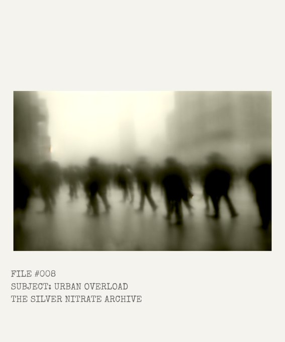 The image features a blurry photo of people walking down a street, with the text "Urban Overload" written below them. The caption also includes the words "The Silver Nitrate Archive", which suggests that this image might be related to an album or collection by @sashelka.