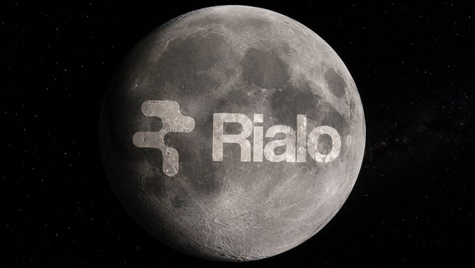 A detailed moon set against a starry black sky, featuring the word 'Rialo' and a logo etched across its surface.