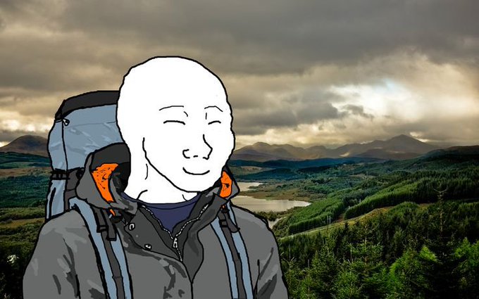 The image shows the classic "Wojak" cartoon character—a bald figure with a contented smile—wearing a hiking jacket and backpack, set against a moody Scottish highland landscape with lochs and mountains beneath cloudy skies. The serene, "at peace" expression of the Wojak visually embodies the post's encouraging "happy Monday" message about starting the crypto week with optimism and readiness to prove one's worth.