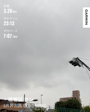 A cloudy, overcast sky fills the frame above streetlights and buildings, with a Garmin fitness app overlay showing a 3.26 km run completed in 23:13 at a 7:07/km pace on 6月27日2026 at 7:42. The gloomy weather in the image matches the post's description of a rainy morning run that was cut short at 3 kilometers.