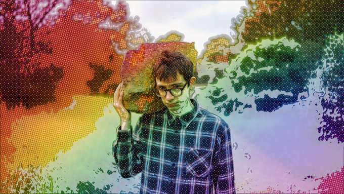 The image features a man wearing glasses standing in front of a colorful background, which includes a rainbow-colored sky with trees and bushes. The man has his arm up in the air while holding a rock above his head. The post that accompanies this image reads "prism holding up well considering the market nuking up well I believe strong nerdy holders are in it. Good sign." This suggests that the man's actions might be related to an event or situation involving the rainbow-colored sky and trees, possibly a celebration or gathering.