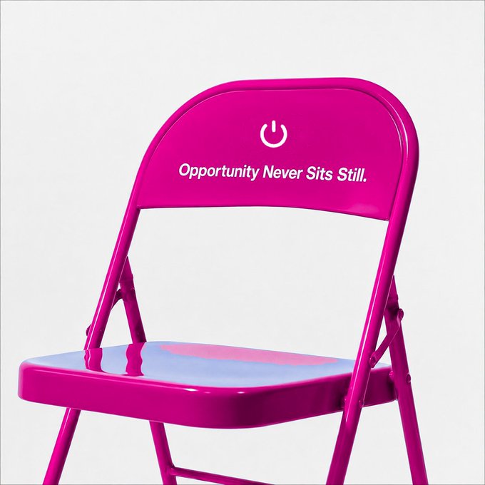 A bright pink folding chair featuring a power button logo and the tagline 'Opportunity Never Sits Still.'