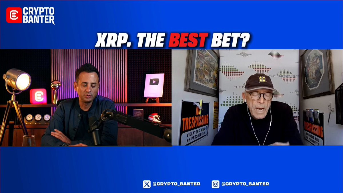 The image features a man sitting at a desk with a microphone, likely recording an interview or podcast. The background of the image shows two men talking about Bitcoin and Ripple. One man is wearing glasses and has a serious expression while discussing the best bet for investing in these digital currencies. The other man appears to be more relaxed and casual in his attire. The post includes text that reads "XRP. XPT. Rp. The Best Bet?". This suggests that the image might have been taken during an interview or podcast where the two men were discussing the best bet for investing in Ripple, with one of them being a Bitcoin expert.