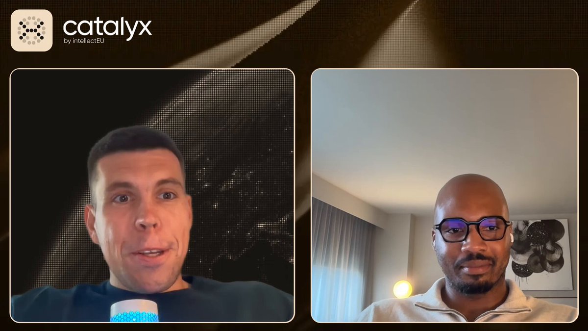 The image shows two men having a video call, both wearing glasses. They are positioned against a brown background that includes text about a new deployment of the first multi-signature deployment on Canton. The man on the left side of the screen is holding a cup in his hand and appears to be engaged in conversation with the other person.