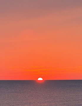 A glowing orange sunset dips just above the ocean horizon, casting a warm, radiant light across the water. The image visually echoes the post's optimistic "future so bright" sentiment, symbolizing the promising outlook for $MOG.