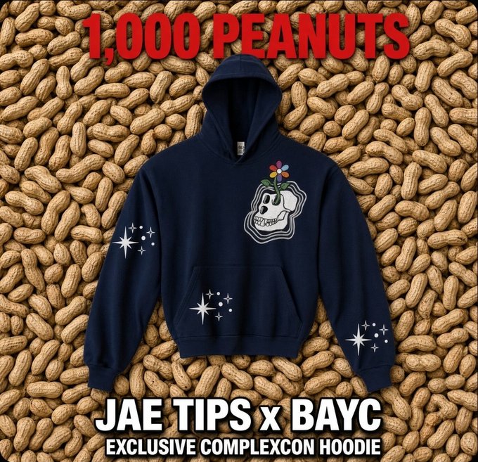 A navy blue hoodie featuring a skull with a flower growing from it, displayed on a background of peanuts, with text reading '1,000 PEANUTS', 'JAE TIPS x BAYC', and 'EXCLUSIVE COMPLEXCON HOODIE'.