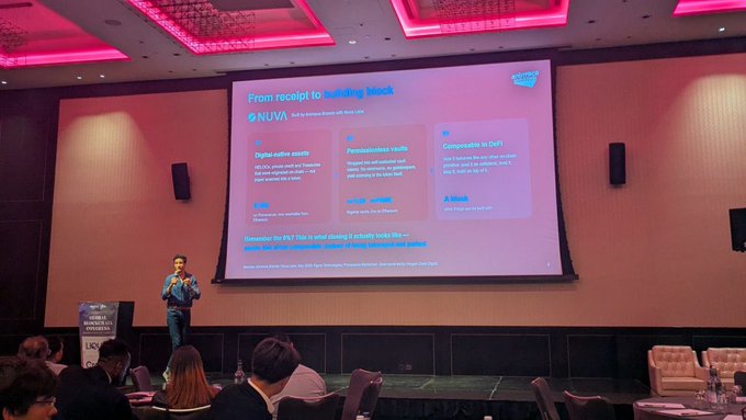 A conference hall with a speaker presenting on a screen titled 'From receipt to building block' about NUWA, featuring sections on Digital native assets, Personalized reality, and Composable in DeFi.