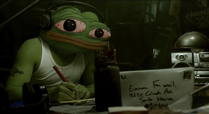 An image of a person wearing a green Pepe the Frog mask and a white tank top, writing with a pen at a desk that has an envelope addressed to 'Emun, Far west, 2220 Cohada Ave, South Houston, 77015-1069' and a boombox in the background.