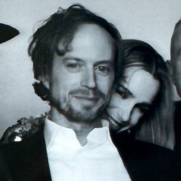 The image shows a man wearing a suit jacket, standing next to a woman who has long hair. They are both smiling at the camera. The photo appears to be black and white, giving it an artistic feel. There is no text present in the image, but there is a caption that reads "Send BTC to this address. You’ll get more or nothing Erik Voorhees — 2012. works at BitInstant. — builds SatoshiDice as a side project." This caption suggests that the man and woman are involved in some sort of online business related to Bitcoin, possibly running an eBay shop selling Bitcoin coins.