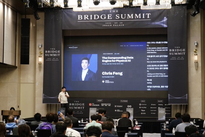 A presentation at 'THE BRIDGE SUMMIT' held on 2026-09-29 at Josun Palace, featuring Chris Feng, Co-founder & CEO of ROBOTICS, speaking on 'The Compounding Data Engine for Physical AI'.