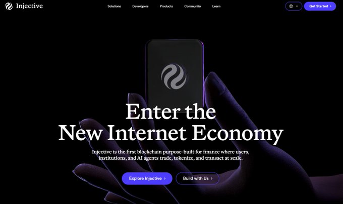 The image shows Injective's newly redesigned homepage with the headline "Enter the New Internet Economy," featuring a hand holding a smartphone displaying the Injective logo against a dark background, with navigation links (Solutions, Developers, Products, Community, Learn) and CTA buttons ("Explore Injective," "Build with Us"). This directly reflects the post announcing the refreshed, cleaner Injective website design that serves as the main entry point to the platform's offerings.