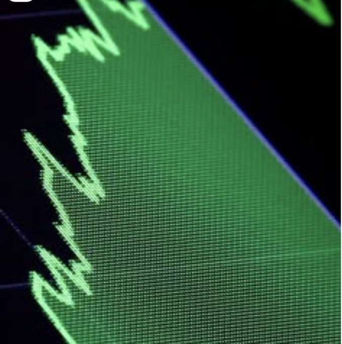 A close-up photograph of a digital screen displaying a green line graph trending upwards against a dark background, indicative of positive market performance.