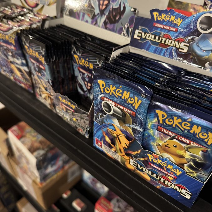 Shelves stocked with Pokémon Trading Card Game 'Evolutions' booster packs displayed at a retail store.