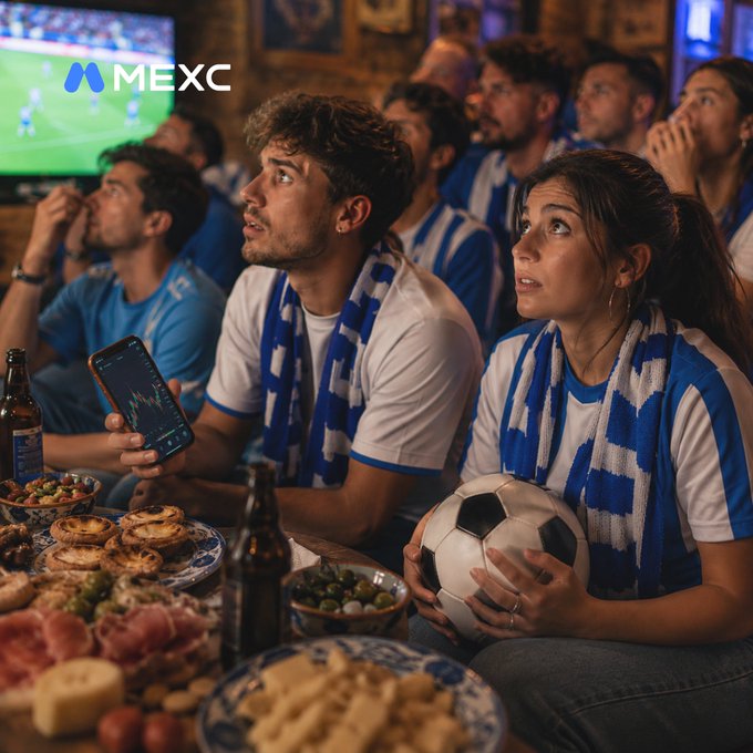A group of soccer fans wearing blue and white scarves watch a tense match intently, with the MEXC logo visible on the screen above, while one fan checks a price chart on their phone—mirroring the post's theme of staying glued to both thrilling games and volatile crypto charts.