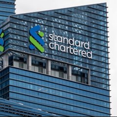 The image shows the Standard Chartered bank logo and name on a sleek glass skyscraper, representing the company that, according to the post, plans to launch $450 billion in crypto custody services for institutional investors in Singapore.