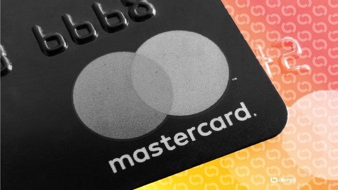The image shows a close-up view of a black Mastercard credit card with white text that reads "Mastercard". The card has two circles on its top edge, one larger than the other, which are the company's logo. The background is a patterned orange and yellow color scheme. In the corner of the image, there is a post that says "JUST IN: Mastercard expands stablecoin settlement to include Circle'S $USDC and Ripple (XRP)'s RLUSD." This indicates that the card has been expanded to include new payment methods such as Bitcoin Cash and Ripple's cryptocurrency. The text also mentions that this expansion is happening 24/7, which means that users can continue to make payments using these new methods without any disruptions or limitations.
