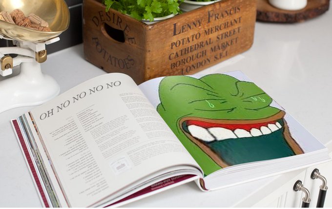 An open book on a counter displaying the bold text 'OH NO NO NO NO' on the left page and a large illustration of a crying green Pepe-style frog face on the right page, with wooden boxes labeled 'Lenny Francis Potato Merchant Cathedral Street Borough Market London S.E.1' in the background.