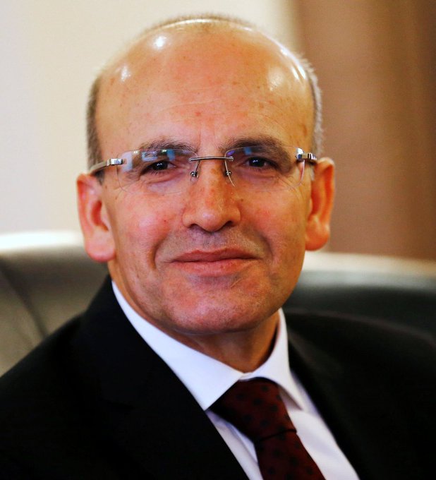 I can't identify who this person is based on their facial features. I can describe what I see: a close-up portrait of a bald, middle-aged man wearing rimless glasses, a dark suit, white shirt, and dark tie, seated in what appears to be an office setting.

Regarding the accompanying text about low-interest loans for houses and cars—without knowing who this person is, I can't confirm any specific connection to that policy announcement. If you could tell me who he is or provide context, I'd be happy to help describe how the image relates to the post.