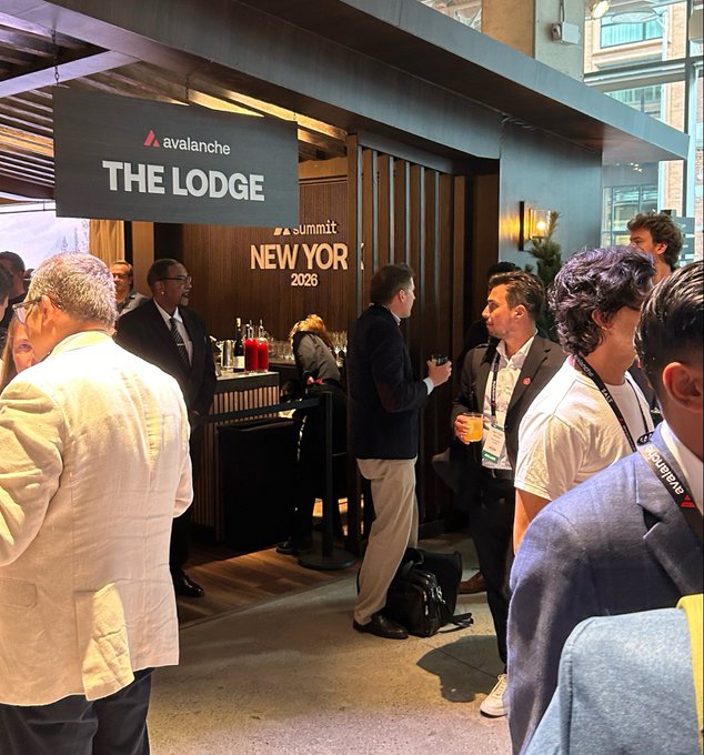 People networking at an Avalanche event called "THE LODGE" during "Summit New York 2026," with attendees holding drinks near a bar.