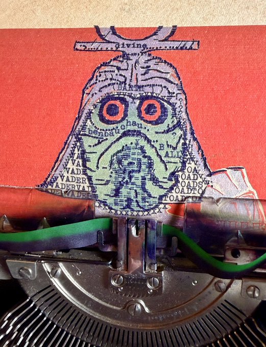 A mixed-media artwork on red paper depicts a bell-shaped figure composed of dollar bill imagery with text like 'divine' and 'benevolent', positioned above a typewriter mechanism with red-stained paper.