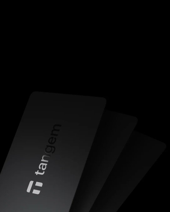Three black cards fanned out in the dark, with the front card displaying the 'tangem' logo.