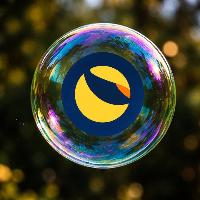 A colorful iridescent soap bubble floats against a blurred natural background, displaying the Terra (LUNA) cryptocurrency logo in its center—a dark blue circle with a yellow crescent and orange accent.