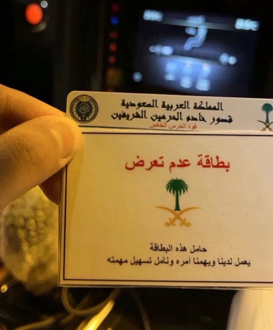 A hand holds up a Saudi Arabian border crossing permit card from the General Directorate of Passports, with bold red Arabic text reading "بطاقة عدم عرض" (No Objection/Exemption Card). The post's question about what the card means and how to obtain it is directly answered by the card itself, which states that the holder—being a female—works for the holder's spouse and facilitates her profession, likely a permit allowing women to cross certain checkpoints or work in specific roles.