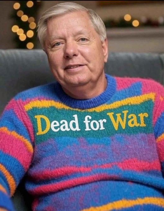 A photograph of U.S. Senator Lindsey Graham smiling while wearing a colorful striped sweater with the text 'Dead for War' displayed on the front.