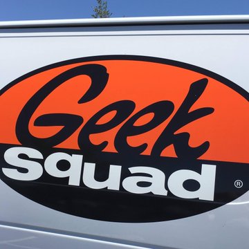 A close-up of the orange and black 'Geek Squad' logo on a vehicle.